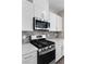 Close-up of a modern kitchen featuring stainless steel appliances, light countertops, and stylish backsplash tiling at 2367 Ridgeline Wash St, Las Vegas, NV 89138
