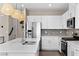 Modern kitchen features stainless steel appliances, white cabinetry, quartz countertops, and decorative pendant lighting at 2367 Ridgeline Wash St, Las Vegas, NV 89138