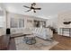 Bright living room featuring a comfortable sectional sofa, modern ceiling fan, and sliding door access to the backyard at 2367 Ridgeline Wash St, Las Vegas, NV 89138