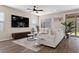 Comfortable living room showcasing a large sectional sofa, wood-like floors, and a view of the backyard through sliding glass doors at 2367 Ridgeline Wash St, Las Vegas, NV 89138