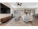 Bright living room featuring a large sectional sofa, stylish coffee tables, and sliding glass doors leading to the backyard at 2367 Ridgeline Wash St, Las Vegas, NV 89138