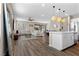 Open-concept living space with wood floors, a stylish sectional sofa, and a modern kitchen island with pendant lighting at 2367 Ridgeline Wash St, Las Vegas, NV 89138