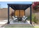 Beautiful backyard patio featuring a modern pergola with comfortable seating and a fire pit perfect for outdoor relaxation at 2367 Ridgeline Wash St, Las Vegas, NV 89138