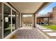 Covered patio with paver flooring, leading to an outdoor seating area and a glimpse of the home's interior through sliding doors at 2367 Ridgeline Wash St, Las Vegas, NV 89138
