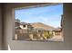 A framed view of the community, featuring tan buildings and mountain backdrop at 2367 Ridgeline Wash St, Las Vegas, NV 89138