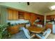 Warm kitchen nook features a round table, wooden cabinets, desk, and plants at 2386 Hardin Ridge Dr, Henderson, NV 89052