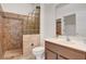 Full bathroom with tiled shower, glass block, vanity with sink, and mirror at 2512 Libretto Ave, Henderson, NV 89052