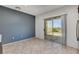 Living room with tiled floor, gray accent wall, and sliding doors to the backyard at 2512 Libretto Ave, Henderson, NV 89052