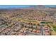 Expansive aerial view showcasing a residential area adjacent to a pristine green golf course and mountain range at 2801 Byron Dr, Las Vegas, NV 89134