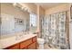 Cozy bathroom with a marble countertop, a large mirror, toilet and patterned shower curtain at 2801 Byron Dr, Las Vegas, NV 89134