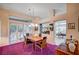 Cozy dining room with backyard access, chandelier, wooden table, and purple carpet at 2801 Byron Dr, Las Vegas, NV 89134
