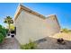 Low-angle view of tan stucco home exterior with rock landscaping and a peek of an outdoor BBQ at 2801 Byron Dr, Las Vegas, NV 89134