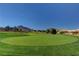 Scenic golf course with lush green fairways, a flag, and mountain views in the background at 2801 Byron Dr, Las Vegas, NV 89134