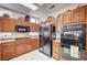 Kitchen features wooden cabinets, black appliances, and white tile flooring at 2801 Byron Dr, Las Vegas, NV 89134