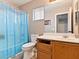 Bathroom featuring a vanity, toilet, window with blinds, and a bathtub with a blue shower curtain at 3040 Balcones Fault Ave, North Las Vegas, NV 89081