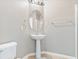 Bathroom with a pedestal sink, oval mirror, and tile flooring at 3040 Balcones Fault Ave, North Las Vegas, NV 89081