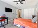 Bright bedroom with a ceiling fan, a mounted television, a closet with white doors, and plush carpeting at 3040 Balcones Fault Ave, North Las Vegas, NV 89081