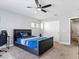 Bright bedroom featuring a ceiling fan, a comfortable bed with a blue comforter, and closet with white doors at 3040 Balcones Fault Ave, North Las Vegas, NV 89081