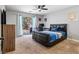 Bright bedroom with a ceiling fan, a sliding glass door, a sleek bed with a blue comforter, and stylish furnishings at 3040 Balcones Fault Ave, North Las Vegas, NV 89081