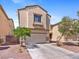 Two-story home featuring a two-car garage, desert landscaping, and a neutral color stucco exterior at 3040 Balcones Fault Ave, North Las Vegas, NV 89081