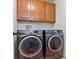 The laundry room has a modern washer and dryer, wooden cabinets, and plenty of space for laundry essentials at 3040 Balcones Fault Ave, North Las Vegas, NV 89081