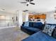 Living room featuring tile and carpet flooring, neutral paint, a ceiling fan, and a large blue sofa at 3040 Balcones Fault Ave, North Las Vegas, NV 89081