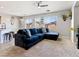 Living room featuring tile and carpet flooring, neutral paint, a ceiling fan, and a large blue sofa at 3040 Balcones Fault Ave, North Las Vegas, NV 89081