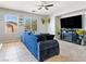 Living room featuring tile and carpet flooring, neutral paint, a ceiling fan, and a large blue sofa at 3040 Balcones Fault Ave, North Las Vegas, NV 89081