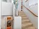 View of the staircase with carpeted steps, a wooden handrail and white banisters, plus a laundry room tucked underneath at 3040 Balcones Fault Ave, North Las Vegas, NV 89081