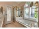 Bright bathroom with a large tub, glass enclosed shower, and shuttered windows at 3088 Paseo Mountain Ave, Henderson, NV 89052