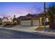 Charming single-story home at night with a tile roof, three-car garage, solar panels, and drought-resistant landscaping at 3088 Paseo Mountain Ave, Henderson, NV 89052