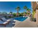 Serene backyard oasis featuring a pool, spa, palm trees, ample seating, and well-maintained landscaping at 3088 Paseo Mountain Ave, Henderson, NV 89052
