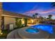 Inviting backyard featuring a sparkling pool, hot tub, lush greenery, and cozy patio under the twilight sky at 3088 Paseo Mountain Ave, Henderson, NV 89052