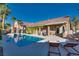 Gorgeous backyard with a swimming pool, lounge chairs, covered patio, and lush landscaping for relaxation and enjoyment at 3088 Paseo Mountain Ave, Henderson, NV 89052
