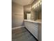Bathroom featuring double sink vanity, large mirror, and modern lighting fixtures at 3340 Shallow Pond Dr, Las Vegas, NV 89117