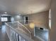 A staircase leads to a second floor in an open-concept home with a modern chandelier at 3340 Shallow Pond Dr, Las Vegas, NV 89117