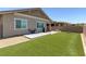 Backyard featuring a well-maintained lawn, stone patio, and relaxing outdoor seating, perfect for entertaining at 379 Mano Destra Ln, Henderson, NV 89011