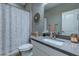 Bathroom with speckled shower curtain, toilet, single sink, and decor at 379 Mano Destra Ln, Henderson, NV 89011