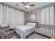 Cozy bedroom with a ceiling fan, comfortable armchair, and a crib at 379 Mano Destra Ln, Henderson, NV 89011