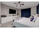 Well-lit bedroom with wide dresser, large TV, and a bench at the foot of the bed at 379 Mano Destra Ln, Henderson, NV 89011