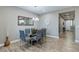 Open dining room features a modern chandelier, a glass-top table, and wood-look floors at 379 Mano Destra Ln, Henderson, NV 89011