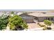 Single-story house showcasing desert landscaping with mature trees, a brick driveway, and an attached two-car garage at 379 Mano Destra Ln, Henderson, NV 89011