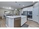 Bright kitchen featuring a large island with sink and stainless steel appliances, and wood-look floors at 379 Mano Destra Ln, Henderson, NV 89011