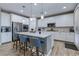 Bright kitchen boasts a large island, white cabinetry, stainless steel appliances, and pendant lighting at 379 Mano Destra Ln, Henderson, NV 89011