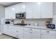 Bright kitchen featuring white cabinetry, quartz countertops, stainless steel appliances, and tile backsplash at 379 Mano Destra Ln, Henderson, NV 89011