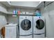 Functional laundry room featuring a sink, shelving and modern washer and dryer units for efficient cleaning at 379 Mano Destra Ln, Henderson, NV 89011