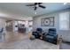 Open-concept living room with wood floors, a ceiling fan, and seamless flow to kitchen at 379 Mano Destra Ln, Henderson, NV 89011
