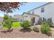 Serene backyard with a covered patio, artificial turf, mature trees, and decorative rock landscaping at 3966 Crystal Trip Ct, Las Vegas, NV 89129