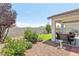 Relaxing backyard with a covered patio, lush artificial turf, mature trees, and decorative rock features at 3966 Crystal Trip Ct, Las Vegas, NV 89129