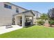 Well-manicured backyard with artificial turf, covered patio, comfortable seating, and lush plantings at 3966 Crystal Trip Ct, Las Vegas, NV 89129